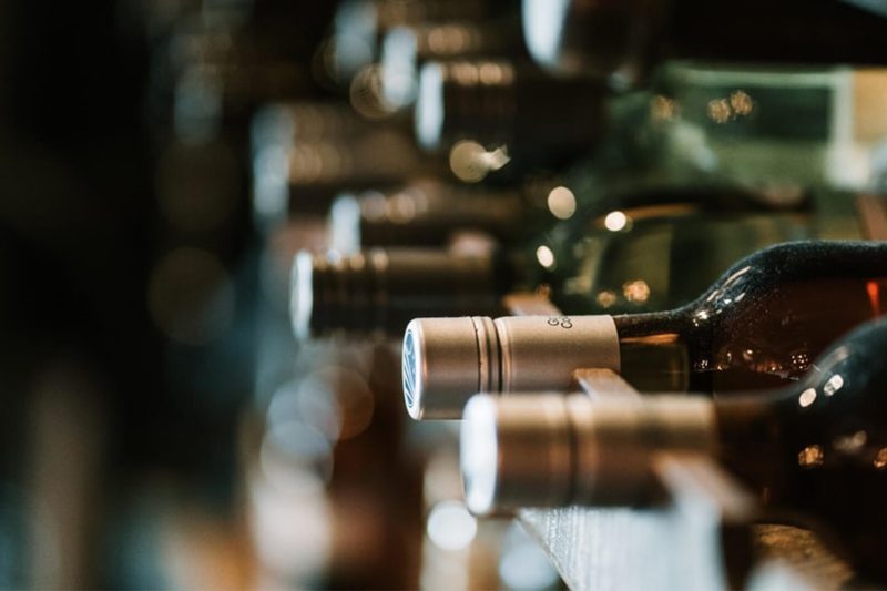 Dusty wine bottles laying in storage in a row